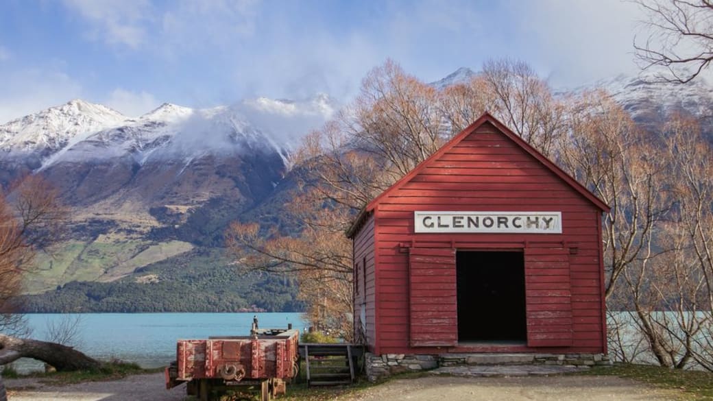 Charming red shed at Glenorchy with stunning alpine backdrop. Perfect for nature and travel enthusiasts.