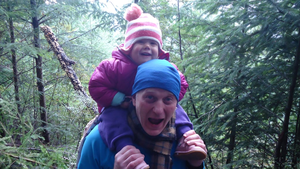 Colin enjoys a forest hike in Queenstown with a little smiling Ayla riding on his shoulders.