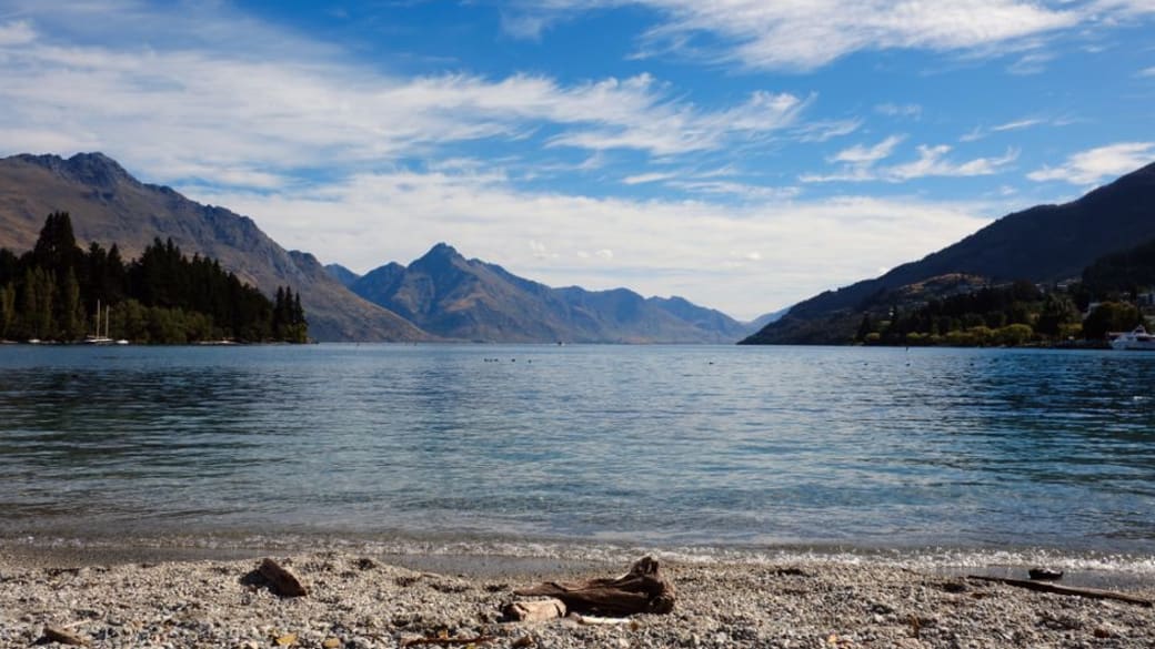 Tranquil views of Lake Wakatipu with surrounding mountains in Queenstown, New Zealand.