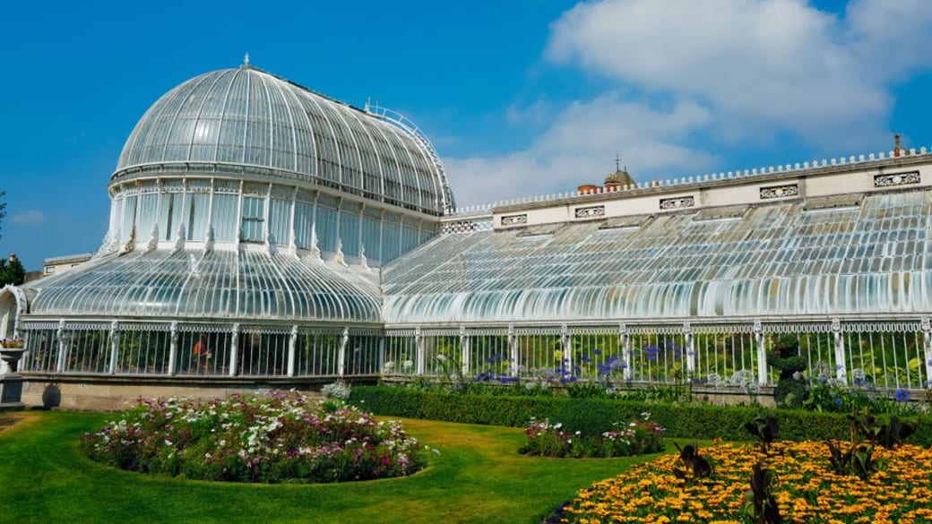 The Palm House in Belfast Botanic Gardens with vibrant floral displays.