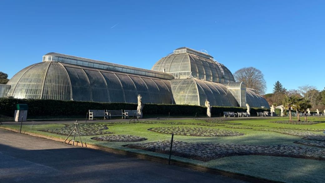 Historic Palm House at Kew Gardens, showcasing its Victorian architecture.
