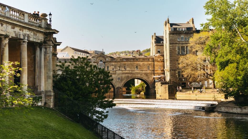 The renowned Pulteney Bridge in Bath, spanning the River Avon, framed by elegant Georgian buildings.