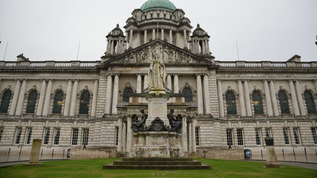 Front view of Belfast City Hall showcasing its architectural grandeur and historic statue.