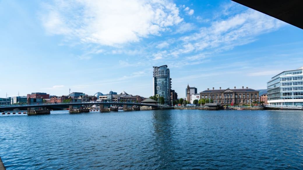 View of the Lagan River with the Belfast skyline, showcasing modern and historic architecture.
