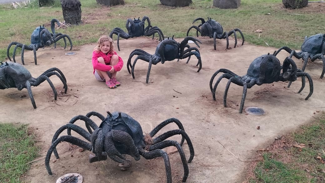 Romy sits beside the soldier crab sculpture at Lammermoor Beach on the Capricorn Coast.